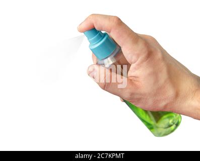 Gros plan de la main en appuyant sur le spray vert. Bouteille à vaporiser. Désinfectant pour les mains à portée de main avec un fond blanc isolé Banque D'Images