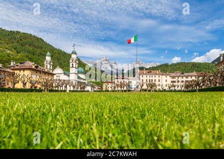 Le centre d'Agordo avec l'église avec deux tours de cloche et la grande pelouse verte appelée 'broi', agordino, belluno, vénétie, italie Banque D'Images