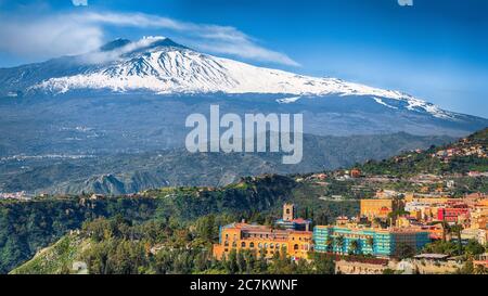 Vue panoramique sur le volcan Etna et la ville de Taormine. Toits de beaucoup de cloisons. Volcan du Mont Etna, couvert de neige. Taormina, Sicile, Italie. Banque D'Images