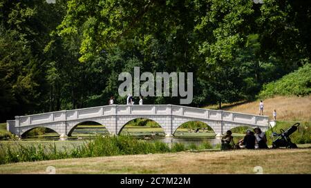 Les gens apprécient le temps ensoleillé à Painshill, jardin paysager du XVIIIe siècle à Cobham, Surrey. Banque D'Images