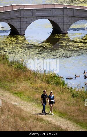 Les gens apprécient le temps ensoleillé à Painshill, jardin paysager du XVIIIe siècle à Cobham, Surrey. Banque D'Images