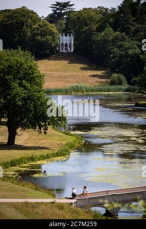 Les gens apprécient le temps ensoleillé à Painshill, jardin paysager du XVIIIe siècle à Cobham, Surrey. Banque D'Images