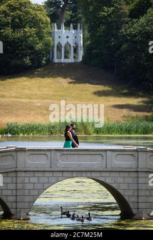 Les gens apprécient le temps ensoleillé à Painshill, jardin paysager du XVIIIe siècle à Cobham, Surrey. Banque D'Images