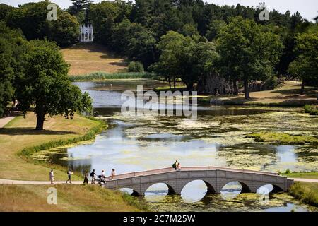 Les gens apprécient le temps ensoleillé à Painshill, jardin paysager du XVIIIe siècle à Cobham, Surrey. Banque D'Images