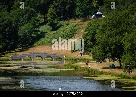 Les gens apprécient le temps ensoleillé à Painshill, jardin paysager du XVIIIe siècle à Cobham, Surrey. Banque D'Images