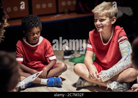 Soins d'équipe sur le sport jeune garçon après accident physique.Sports formation de soccer. Banque D'Images