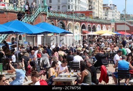 Les clients apprécient les bars extérieurs et le temps ensoleillé sur Brighton Beach. Banque D'Images