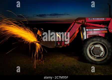 Ouvrier agricole utilisant le moulin à ange la nuit. Banque D'Images