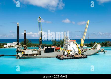 Navire industriel avec de grandes grues travaillant dans le port de Nassau le long de la côte de Paradise Island (Bahamas). Banque D'Images