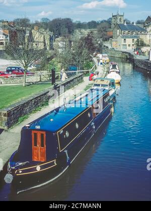 C'est le canal de Skipton vers 1990 dans la ville de Skipton dans le Yorkshire Dales à la jonction du canal Leeds-Liverpool d'où les matières textiles auraient été transportées pendant l'ère victorienne vers et depuis les usines locales de laine et de coton à Leeds-Liverpool et Manchester et au-delà. Banque D'Images