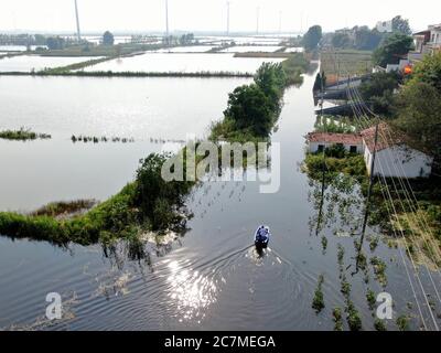 (200718) -- JIUJIANG, 18 juillet 2020 (Xinhua) -- sur cette photo aérienne, Zhang Heng envoie son père à Jiujiang, dans la province de Jiangxi, en Chine orientale, le 17 juillet 2020. Zhang Heng, 27 ans, était autrefois membre des gardes du drapeau national. Il a choisi de retourner dans sa ville natale pour travailler comme agriculteur et prendre soin de ses parents après avoir terminé son service militaire. Bien que ses 60 champs de mu (environ 4 hectares) aient été gravement endommagés par les inondations cette année, Zhang Heng a activement participé aux efforts de contrôle des inondations avec son père. « J'avais l'habitude de protéger l'honneur et la dignité de mon pays, et maintenant je suis gua Banque D'Images