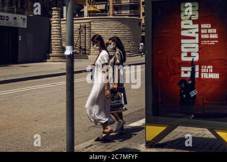 Barcelone, Espagne. 18 juillet 2020. Les voyageurs portant un masque facial protecteur parcourent une publicité de cinéma qui lit « l'effondrement - vous n'avez jamais rien vu de tel », alors que le gouvernement catalan a exhorté les habitants de la région métropolitaine de Barcelone à rester chez eux face à l'augmentation quotidienne la plus abrupte des nouveaux cas COVID-19 après avoir émergé d'un confinement à l'échelle nationale mesures il y a moins d'un mois. Crédit: Matthias Oesterle/Alamy Live News Banque D'Images