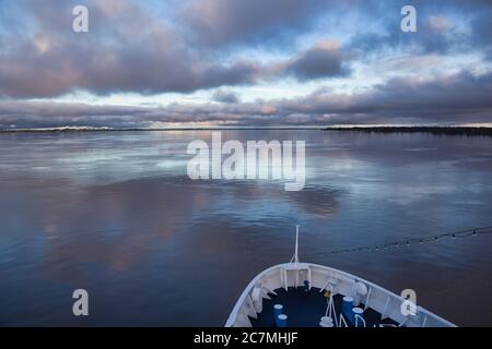 Vue depuis les arceaux d'un navire de la rivière Amazone en avant sur une journée très calme, avec de belles réflexions du ciel et des nuages dans la surface lisse de l'eau Banque D'Images