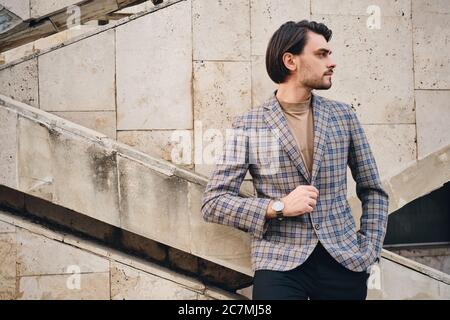 Vue latérale d'un jeune homme beau en veste à carreaux, en toute confiance, en regardant de côté à l'extérieur Banque D'Images