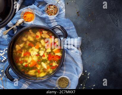 Grande casserole bleue avec soupe de poulet maison et épices bols sur fond bleu Banque D'Images