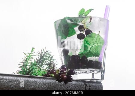 cocktail de baies, menthe, glace dans un rox verre sur le bord d'un comptoir de bar fond blanc. vue bot, gros plan, orientation horizontale Banque D'Images