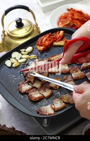 Samgyeopsal cuit ( barbecue de poitrine de porc grillé ), coupé avec des ciseaux Banque D'Images