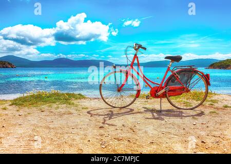 Vue étonnante du matin sur la plage de Tramariglia et vélo rouge vintage garés sur le sable. Lieu: Alghero, province de Sassari, Italie, Europe Banque D'Images