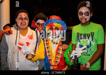 10-31-2017 Tulsa USA quatre garçons afro-américains dans la peinture de visage zombie et un habillé comme un clown donnant deux signes de paix tour ou plaisir sur Halloween Banque D'Images