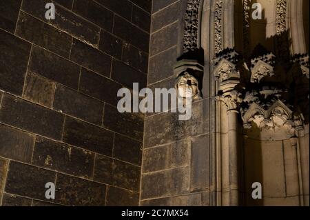 Sculpture de la tête de femme décoration ornementale sur l'ancien bâtiment médiéval fait dans le style gothique - lumière sinistre la nuit. Briques sombres comme zone d'espace de copie Banque D'Images