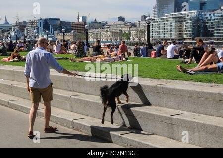 Londres, Royaume-Uni. 18 juillet 2020. Les gens marchent et s'assoient au soleil dans la région autour de l'hôtel de ville et Potters Field Park aujourd'hui. Le centre de Londres semblait aujourd'hui plus occupé avec plus de personnes qui quittait leur maison pour profiter du temps ensoleillé. Les règles de distanciation sociale semblaient être respectées dans la plupart des endroits, mais certaines zones sont déjà bondées. Crédit : Imagetraceur/Alamy Live News Banque D'Images