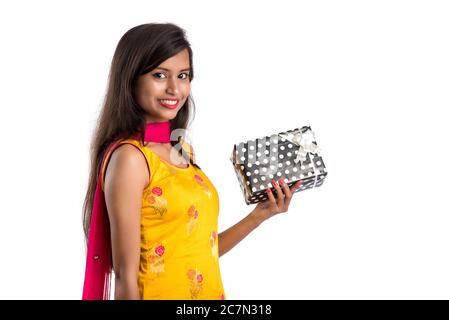 Portrait de jeune fille indienne souriante et heureuse tenant des boîtes-cadeaux sur un fond blanc. Banque D'Images