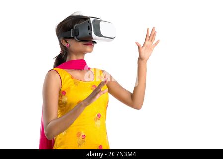 Jeune fille traditionnelle indienne tenant et montrant un appareil VR, boîte vr, lunettes, casque de réalité virtuelle 3D, fille avec l'imagerie moderne future technologie Banque D'Images