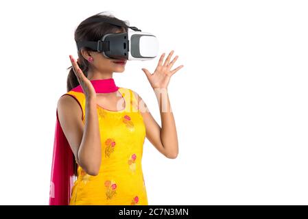 Jeune fille traditionnelle indienne tenant et montrant un appareil VR, boîte vr, lunettes, casque de réalité virtuelle 3D, fille avec l'imagerie moderne future technologie Banque D'Images