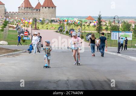 Moldavie, Bender - 18 mai 2019 : un garçon et une fille se livrent à des scooters dans le parc. Banque D'Images