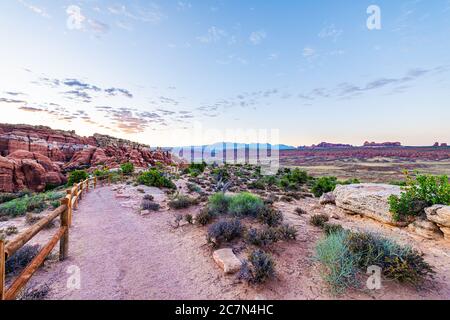Vue panoramique sur le sentier au lever du soleil le matin dans le parc national d'Arches, Utah, États-Unis au point de vue de Fiery Furnace avec paysage et personne Banque D'Images