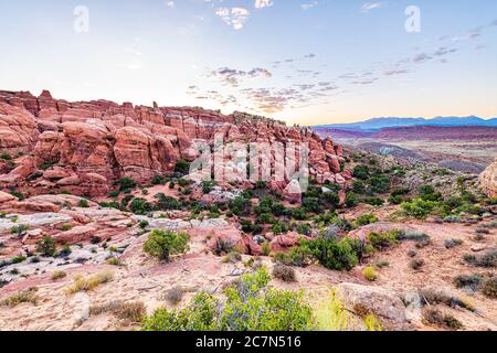 Grand angle au-dessus de la vue du lever du soleil matin dans le parc national d'Arches, Utah, États-Unis, au point de vue de Fiery Furnace avec des plantes d'été vertes et paysagères Banque D'Images