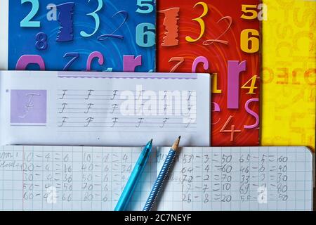 Lettres et exercices mathématiques écrits dans un manuel avec un stylo et crayon sur elle - concept de préscolaire Banque D'Images