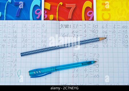 Gros plan grand angle d'un ordinateur portable avec exercices mathématiques, stylo et crayon, carnets Banque D'Images