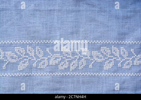 Gros plan d'un tissu denim bleu cousu avec un filetage blanc Banque D'Images