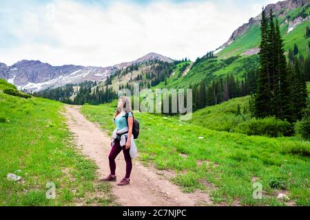 Albion Basin, Utah été avec une femme debout sur un chemin escarpé vue sur le paysage des prés sentier vers le lac Cecret dans les montagnes Wasatch Banque D'Images