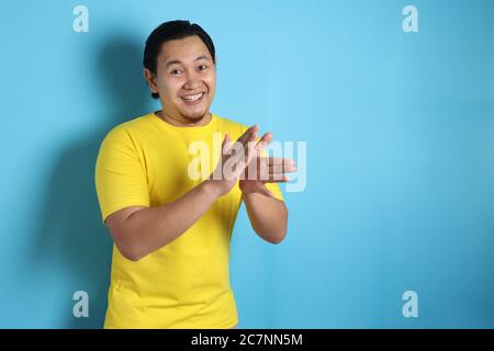 Jeune asiatique portant une chemise blanche, heureux fier clapping geste.sur fond gris, portrait de corps de halfl Banque D'Images