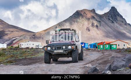 Véhicules japonais à quatre roues motrices Nissan Patrol conduite sur route de montagne en arrière-plan paysage volcanique. Vacances actives, voyage tout-terrain en voyage Banque D'Images