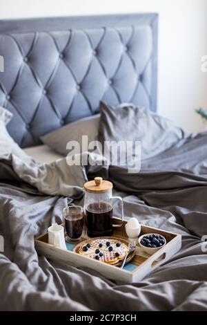 gros plan sur un plateau en bois avec un délicieux petit déjeuner sur le lit Banque D'Images