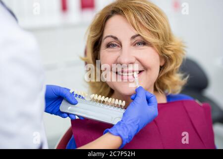 gros plan sur la vérification par le dentiste et la sélection de la couleur des dents de la femme mature Banque D'Images