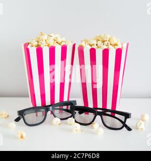 cinema and date concept - deux boîtes à rayures rouges avec pop-corn et lunettes 3d Banque D'Images