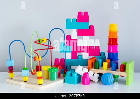 jouets colorés et briques de construction sur fond blanc de mur Banque D'Images