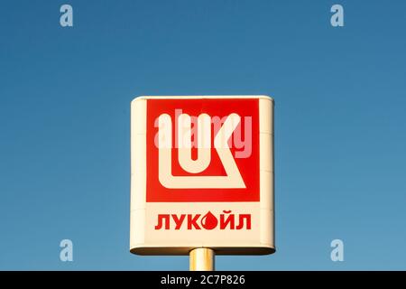 Logo Lukoil et signature en cyrillique par écrit pour la compagnie pétrolière russe Lukoil à l'essence ou à la station-service contre ciel bleu Banque D'Images