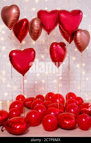 Arrière-plan de la Saint-Valentin - groupe de ballons rouges sur le mur de briques blanches Banque D'Images