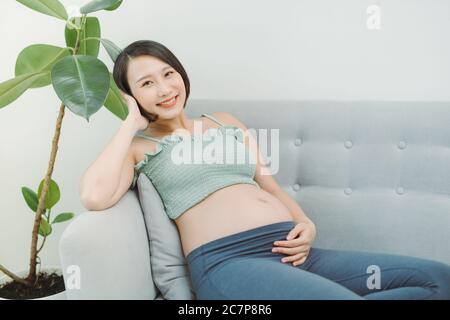 Confortable maison portrait de femme enceinte à la maison de repos sur canapé Banque D'Images