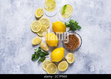 Ingrédients pour rafraîchir la limonade - citrons, menthe, thym, sucre, vue de dessus. Banque D'Images