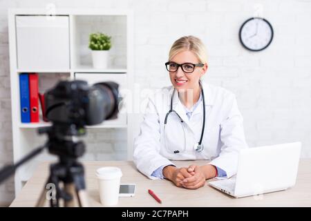 Cheerful belle femme médecin l'enregistrement vidéo vlog sur la médecine et soins de santé Banque D'Images