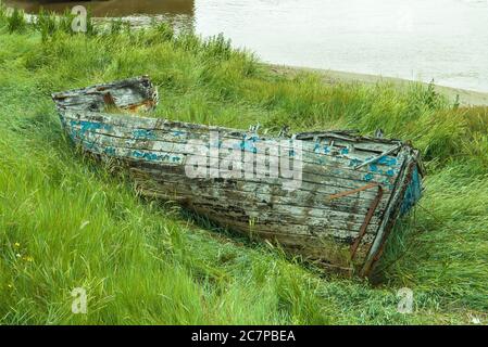 Vieux bateau à rames sur l'herbe à côté de la rivière Great Ouse à Kings Lynn, Norfolk, Royaume-Uni. Banque D'Images
