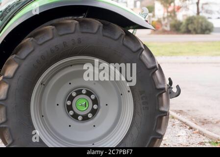 Un garde-boue vert et noir sur une grande roue de tracteur grise et un pneu de tracteur noir sur un terrain de vente en Australie rurale Banque D'Images