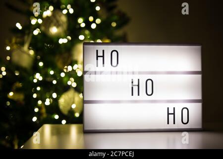 concept de noël - boîte aux lettres avec mot ho-ho-ho dans une pièce sombre avec arbre de noël décoré Banque D'Images