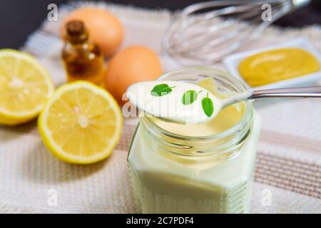 ingrédients pour faire de la sauce mayonnaise maison. moutarde, œufs, huile végétale au citron. Banque D'Images
